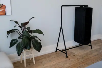 a black tripod next to a plant in a room at Baixa24 •P2R• Bright Apt in Vibrant Downtown in Porto