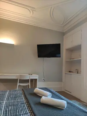 a bedroom with a bed and a flat screen tv at Baixa24 •P1R• Brand New Apt in the Historic Center in Porto