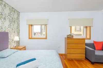 a bedroom with a bed and a couch and a window at Cedofeita Paradise w parking included in Porto
