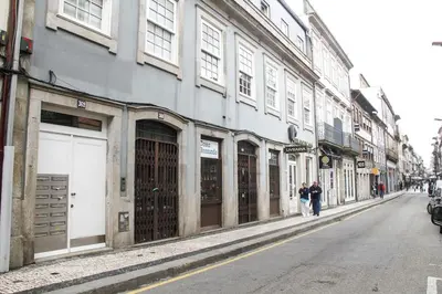 two people walking down a street next to a building at Cedofeita Paradise w parking included in Porto