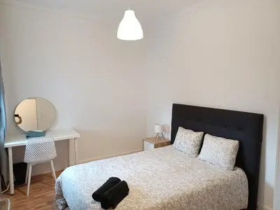 a bedroom with a bed and a desk and a mirror at Oporto Cozy Rooms in Porto