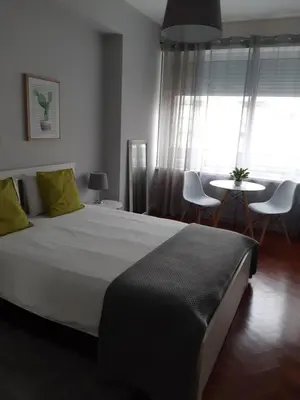 a bedroom with a large bed with a table and chairs at Lolla's City House in Porto