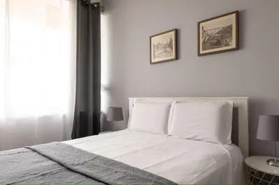 a bedroom with a white bed with two pictures on the wall at Lolla's City House in Porto