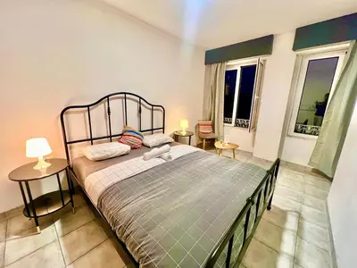 a bedroom with a bed with two tables and two windows at SwissPorto Guest House in Porto
