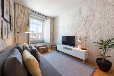 a living room with a couch and a tv at Cativo Apartment - Porto Downtown in Porto