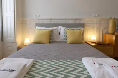 a bedroom with a large bed with yellow pillows at FLH Living Oporto Lofts in Porto