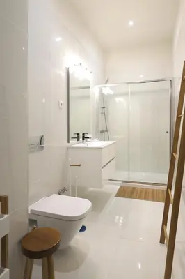 a white bathroom with a toilet and a shower at FLH Living Oporto Lofts in Porto