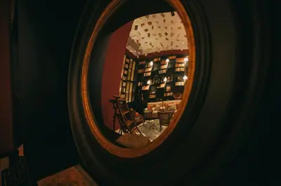 a mirror reflection of a room with a chair in it at Torel Palace Porto in Porto