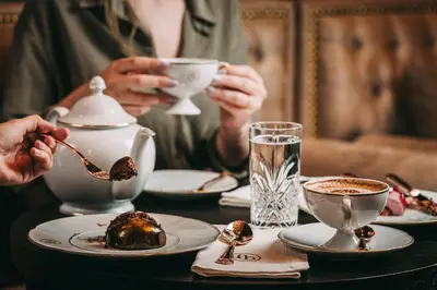 a person sitting at a table with a cup of coffee at Torel Palace Porto in Porto