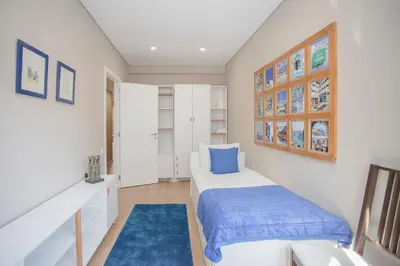 a small bedroom with a bed and a blue rug at Liiiving in Porto - Terrace Downtown Apartment in Porto