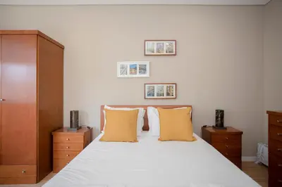 a white bedroom with a blue pillow on a white couch at Liiiving in Porto - Terrace Downtown Apartment in Porto
