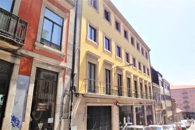 a yellow building on the side of a street at Aspasios Picaria Apartments in Porto