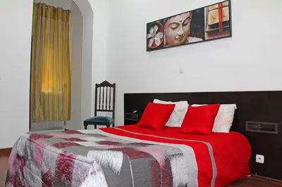 a bedroom with a large bed with red pillows at D. Duarte I in Porto