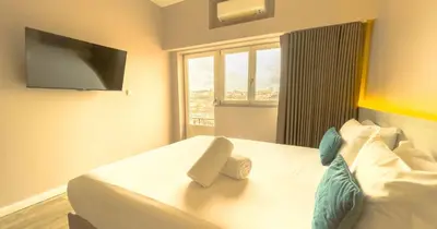 a hotel room with a bed with a tv on the wall at PipaD'oro by YoursPorto in Porto