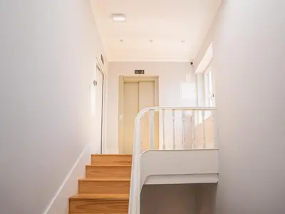 a staircase in a house with white walls and wooden floors at PipaD'oro by YoursPorto in Porto