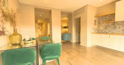 a living room with green chairs and a counter at PipaD'oro by YoursPorto in Porto