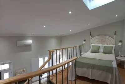 a bedroom with a bed and a wooden staircase at Domus Duorum in Porto