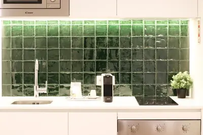 a green tiled wall in a kitchen with a sink at HM - Oporto Cedofeita 500C in Porto