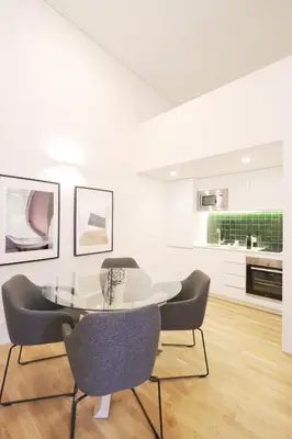 a white dining room with a table and chairs at HM - Oporto Cedofeita 500C in Porto