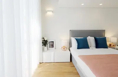 a bedroom with a large bed with blue pillows at HM - Oporto Cedofeita 500B in Porto