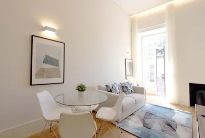 a living room with a white couch and a glass table at HM - Oporto Cedofeita 500B in Porto