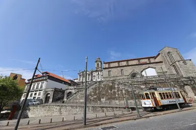 an old building with a tram in front of it at FLH Sá da Bandeira Luxury Apartment in Porto