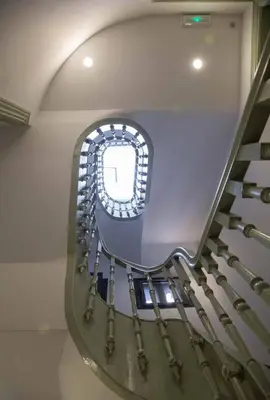 a spiral staircase with a window in a building at GuestReady - Charming Downtown and Quiet Apartment in Porto