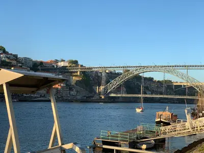 a bridge over a river with a boat in the water at Invicta House Loft Boavista in Porto