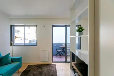 a living room with a blue couch and a window at Casa São Lázaro- Terrace by Oporto Soul in Porto