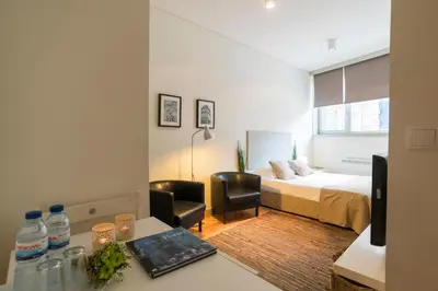 a hotel room with a bed and a desk with a desk at bnapartments Trindade in Porto