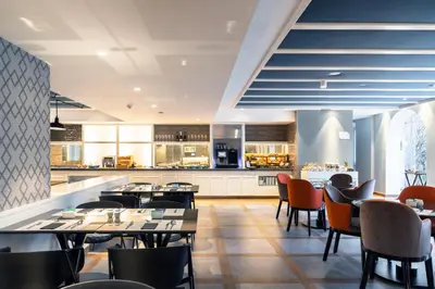 a large room with a swimming pool with glass walls at Catalonia Porto in Porto
