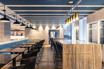 a restaurant with tables and chairs and a bar at Catalonia Porto in Porto