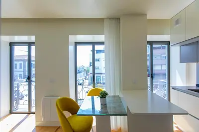 a kitchen with a dining table and yellow chairs at Casa São Lázaro by Oporto Soul in Porto