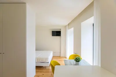 a room with a bed and a table and chairs at Casa São Lázaro by Oporto Soul in Porto