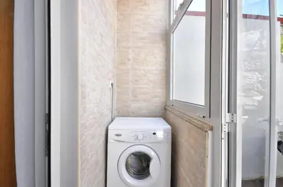 a washing machine in a small bathroom with a window at Jardim do Pilar T1 in Vila Nova de Gaia