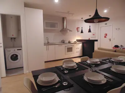 a kitchen and a living room with a table and chairs at Dream Modern House in Porto