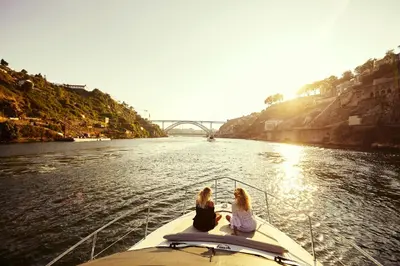 two girls sitting on the back of a boat in the water at Cozy room with lake view in Porto 12 m² and terrace in Porto