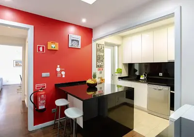 a kitchen with red walls and a black counter top at Porto Gaia City House by MP in Vila Nova de Gaia