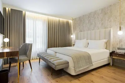 a bedroom with a bed and a desk and a chair at Acta The Avenue in Porto