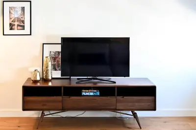 a tv sitting on top of a wooden entertainment center at Oporto Chic&Cozy - Batalha II in Porto
