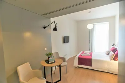 a bedroom with a bed and a table and chairs at Clérigos Prime Suites by Porto City Hosts in Porto