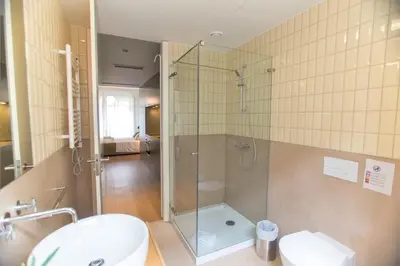 a bathroom with a shower and a toilet and a sink at Clérigos Prime Suites by Porto City Hosts in Porto