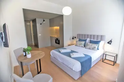 a small bedroom with a bed and a table at Clérigos Prime Suites by Porto City Hosts in Porto