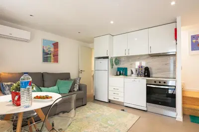 a kitchen and living room with a couch and a table at New Bluebell house in heart of Porto in Porto