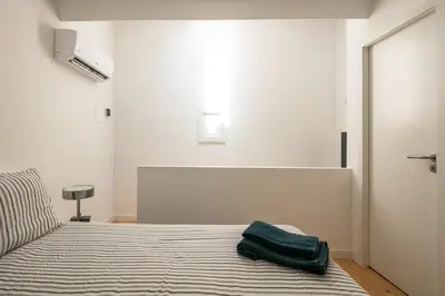 a bedroom with a bed with a green bag on it at New Bluebell house in heart of Porto in Porto