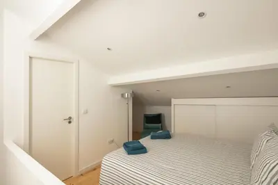 a bedroom with two beds and a green chair at New Bluebell house in heart of Porto in Porto