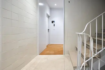 a hallway with white tiled walls and a white staircase at Signature Apartments Santa Catarina in Porto