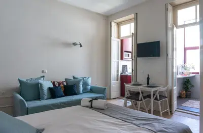 a bedroom with a bed and a couch and a table at Jardim de São Lázaro - Porto Apartments in Porto