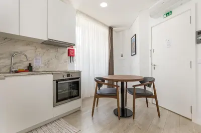 a small kitchen with a table and two chairs at Bra.com Apartments Oporto Faria Guimarães in Porto