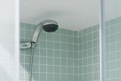 a shower head in a bathroom with blue tiles at GuestReady - Music Flats 2 in Porto